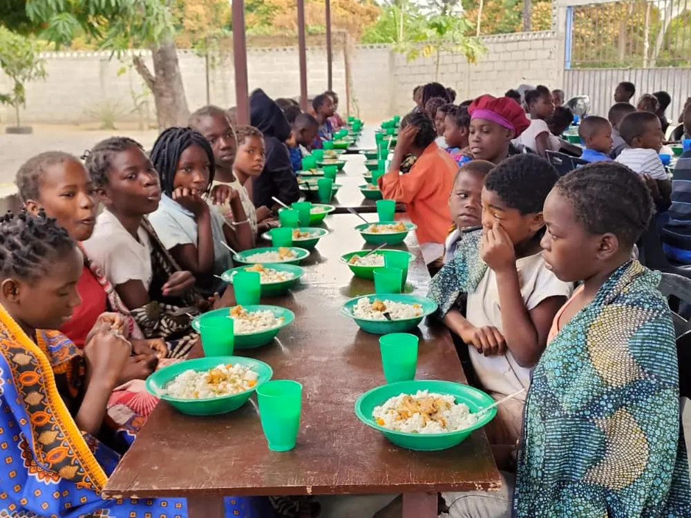 Voluntária da missão junto às mesas durante o almoço